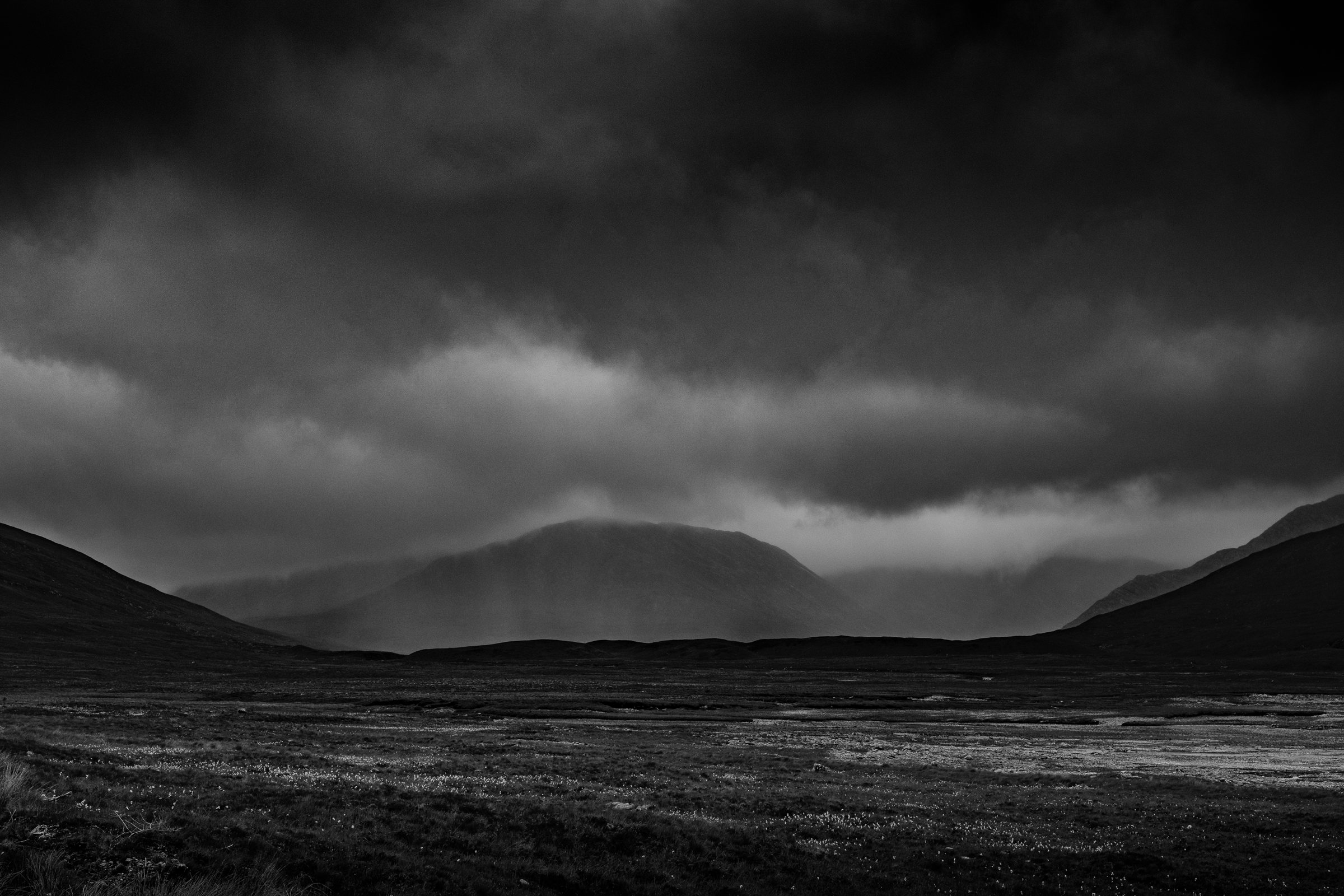 Rain sweeping across hills above the open moor