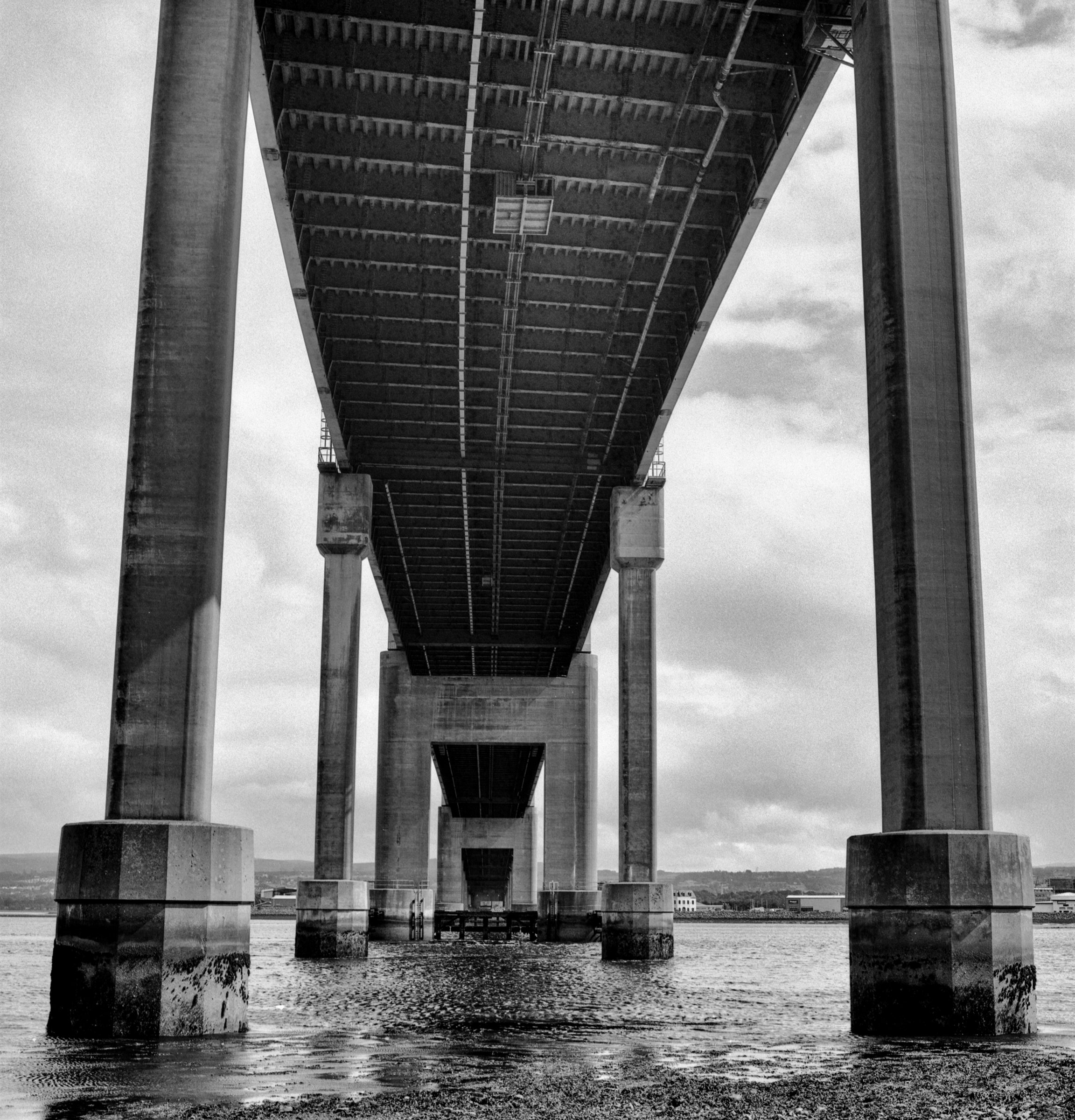 Looking along the underside of the Kessock Bridge over the water