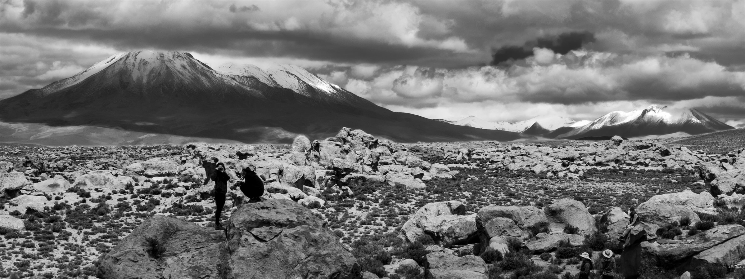 A snow-capped volcano above a rocky plain