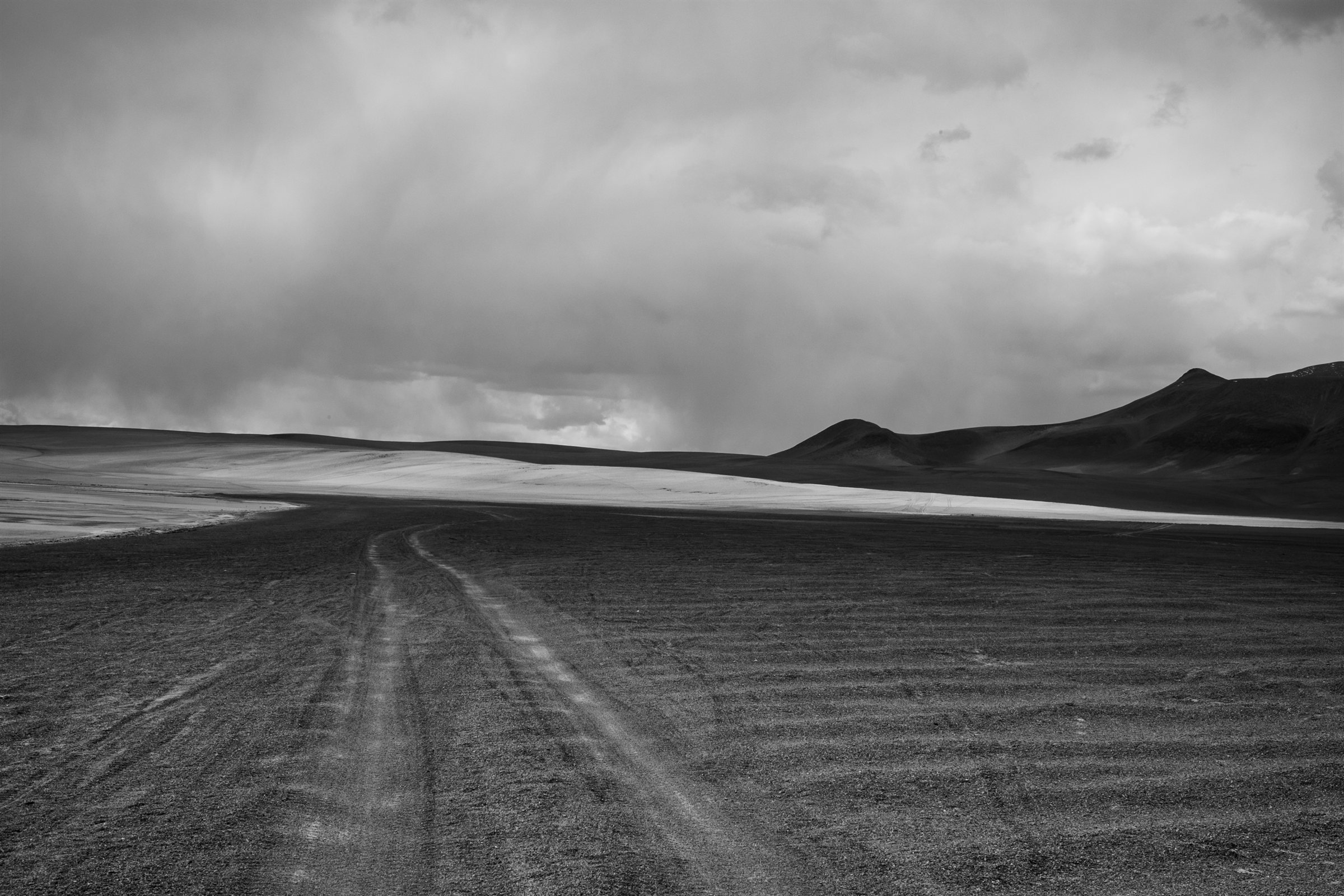 Tyre tracks running across the plain towards the mountains