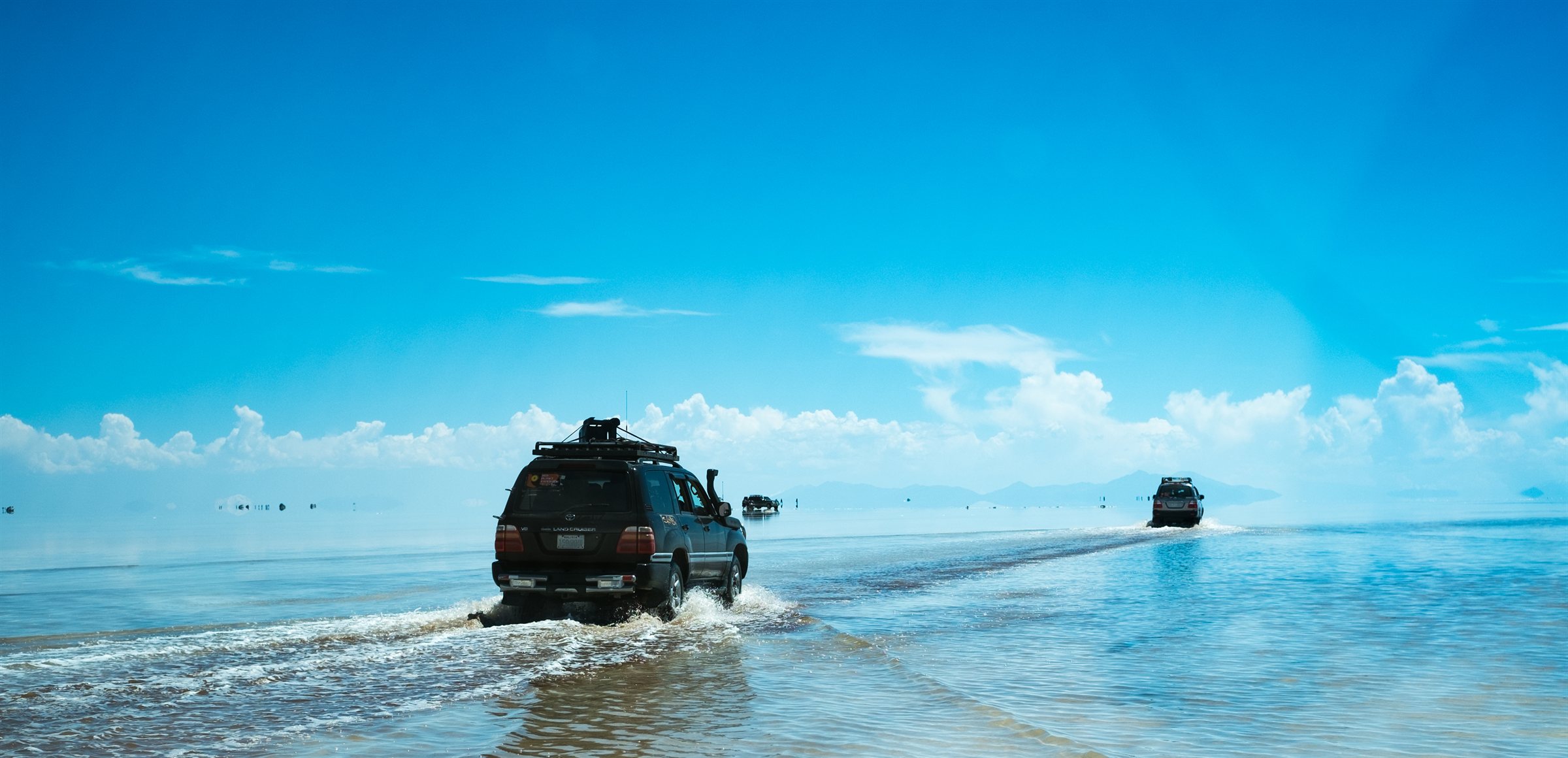 A jeep crossing the flooded salt flats