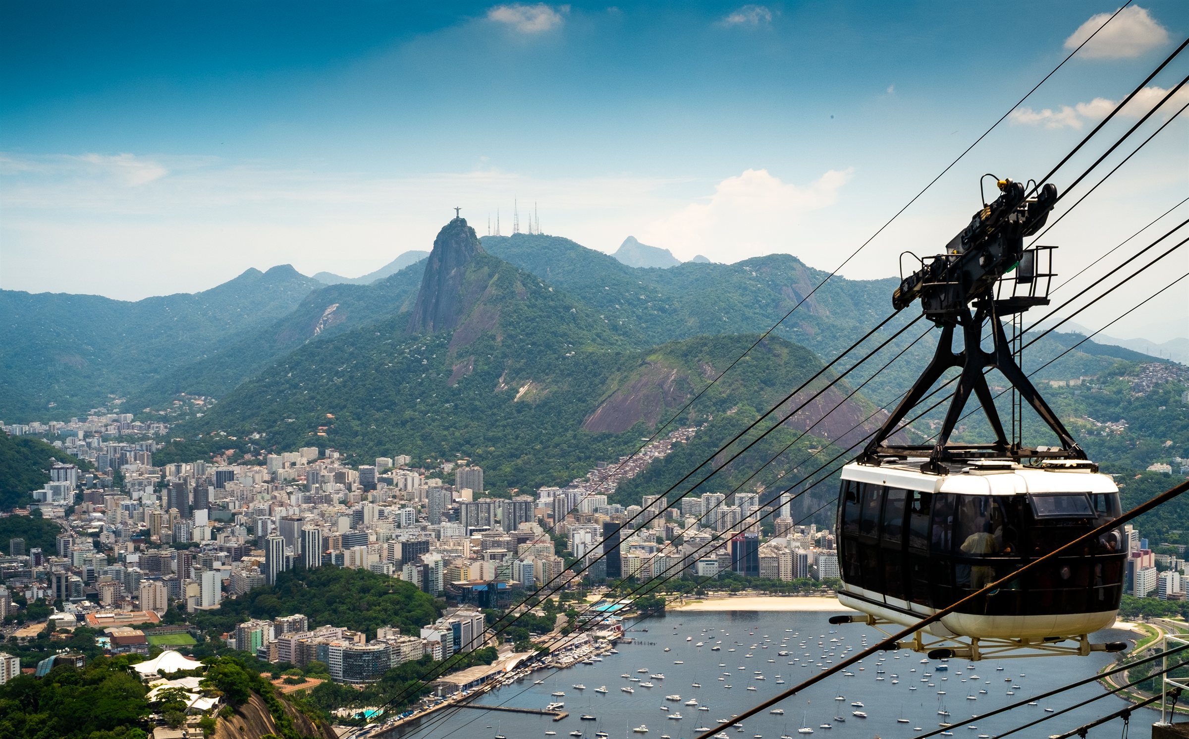 A cable car above Rio, Christ the Redeemer on the mountain beyond