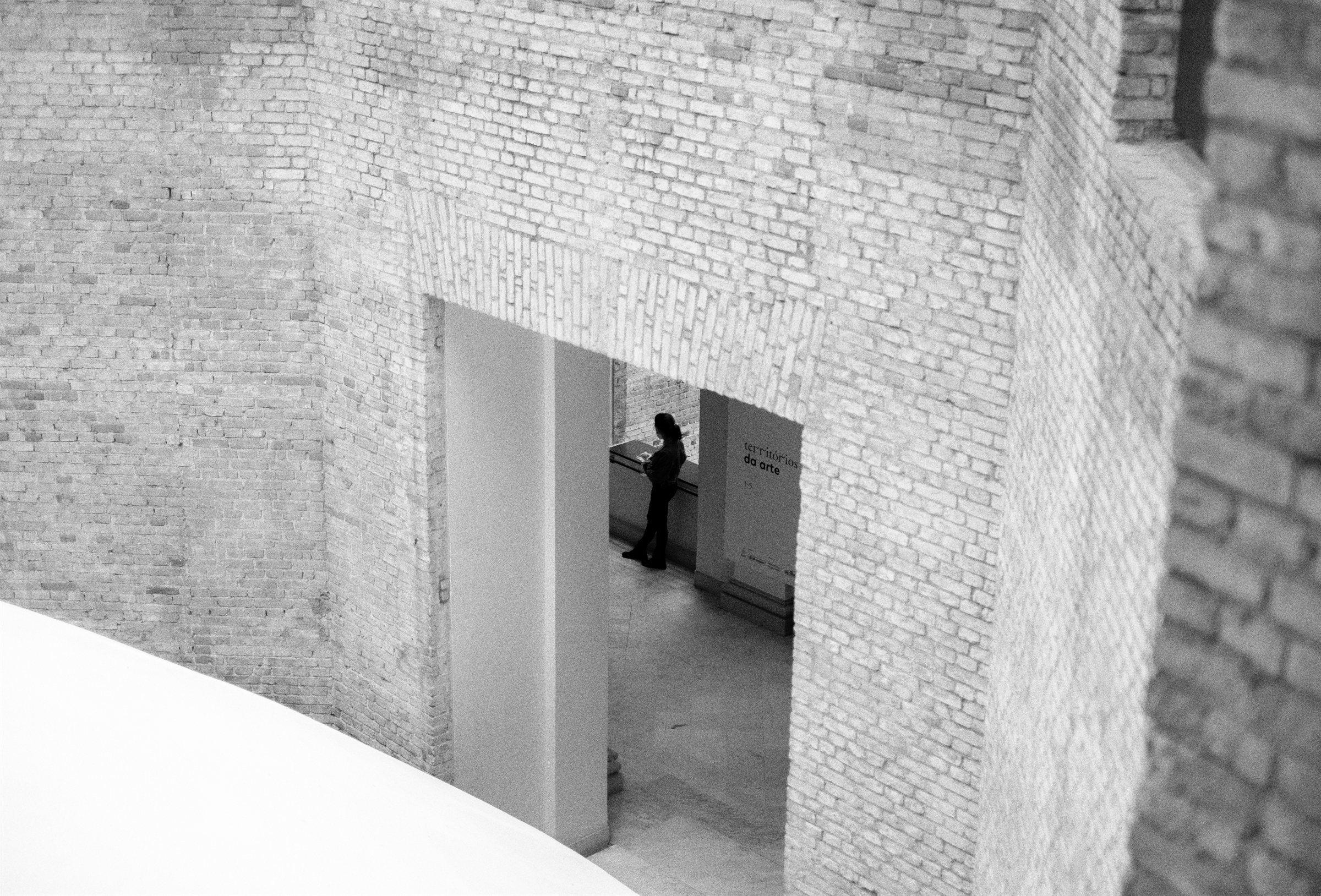 A person in a doorway in a white wall