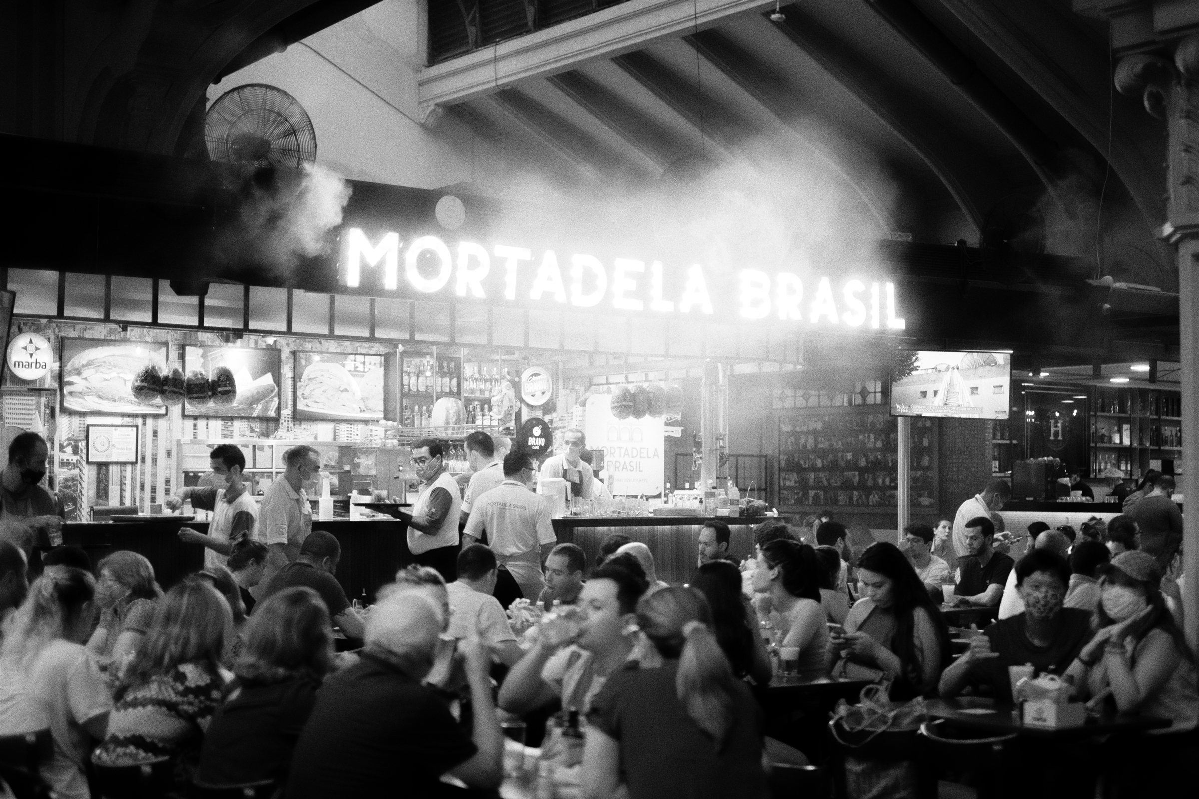 A crowded market bar beneath its big sign