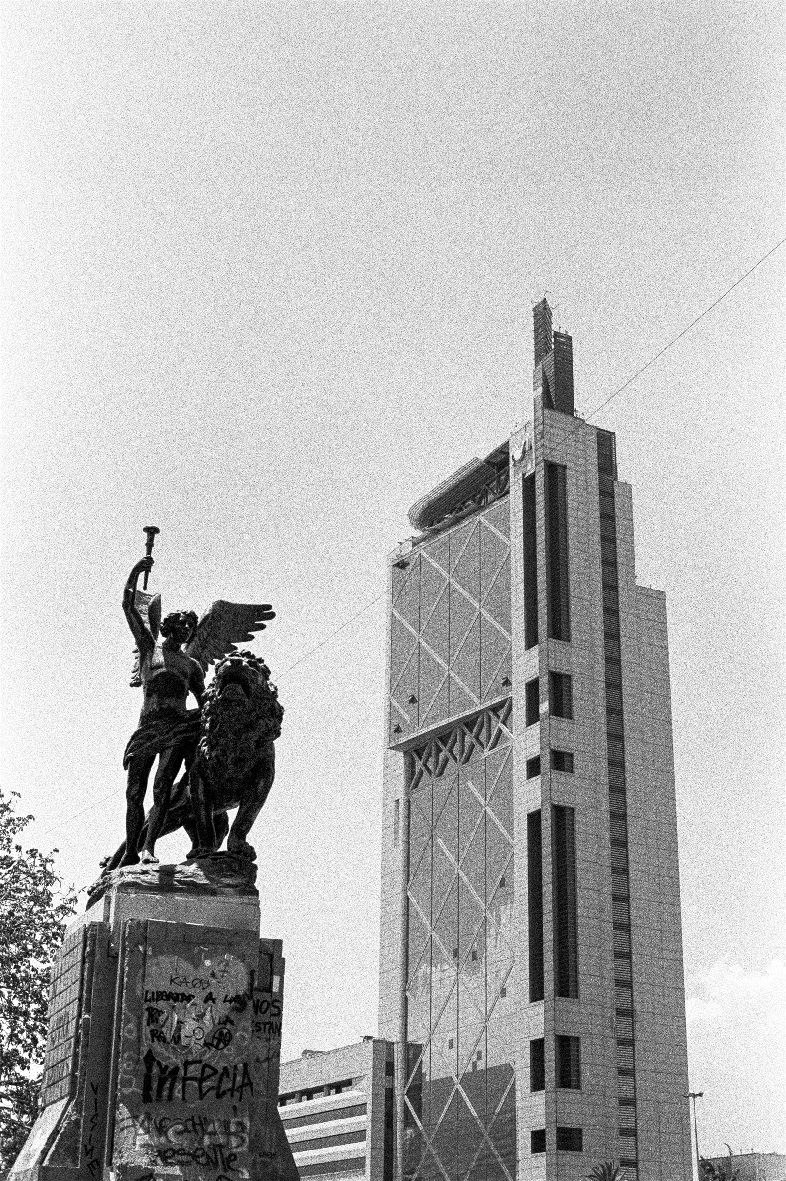 A statue before a tall tower in Santiago